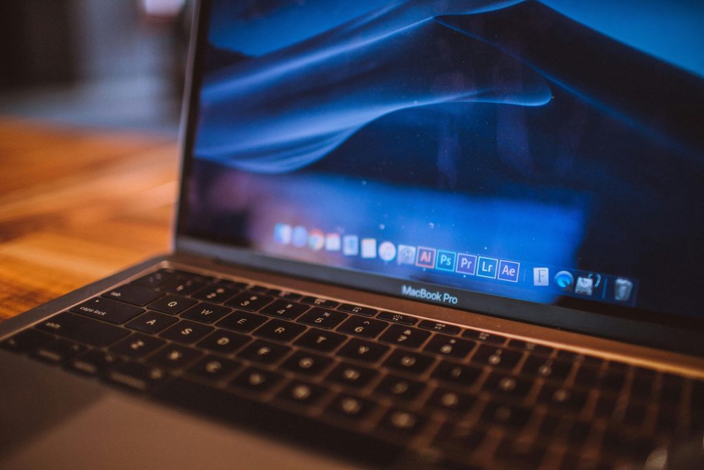pexels photo 2148220 2148220 Close-up view of an open MacBook Pro with a dim blue screen in a cozy indoor setting.